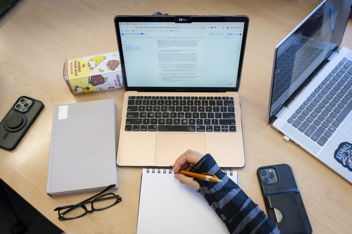 POV view of a student, looking down at laptop with pen and paper